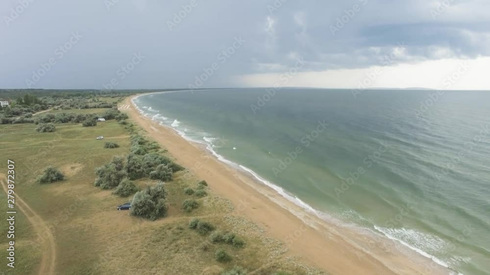 AERIAL: Beach and sea. Landscape of the sea bay with sandy beach, aerial view. Overflight along places of tourist stay near stormy sea on background of thounder cloudscape, aerial video AERIAL: Beach and sea. Landscape of the sea bay with sandy beach, aerial view. Overflight along places of tourist stay near stormy sea on background of thounder cloudscape, aerial video