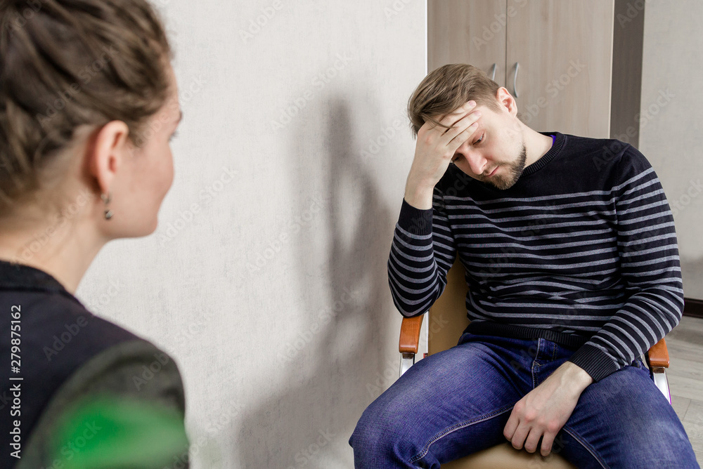 Sad Client a man at a reception at a psychologist solves emotional problems. an ...