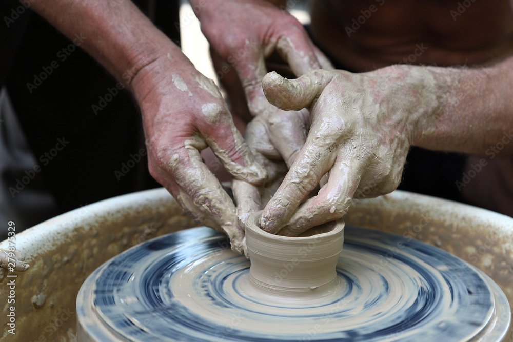 Master of ceramics. We work with clay. The master ceramist teaches the student. Craftsman hands sculpts clay