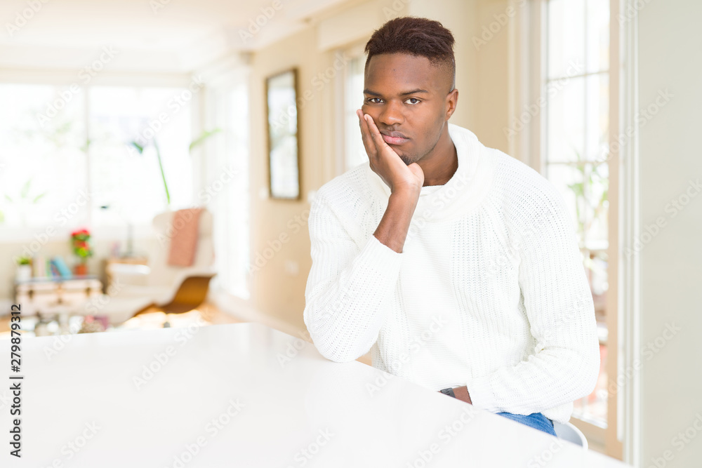 Handsome african american man on white table thinking looking tired and bored with depression problems with crossed arms.