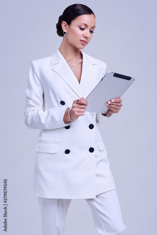 Gorgeous latin women in fashion white suit with digital tablet Gorgeous latin women in fashion white suit with digital tablet