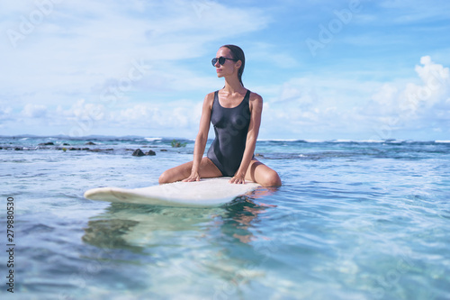 Hobby and vacation. Young sexy woman swimming over surfboard in clear blue water at  beach  Siargao Island  Philippines.