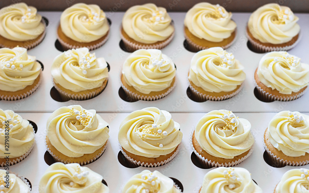 Delicious cupcakes in cardboard box with a hat in the form of a rose Delicious cupcakes in cardboard box with a hat in the form of a rose