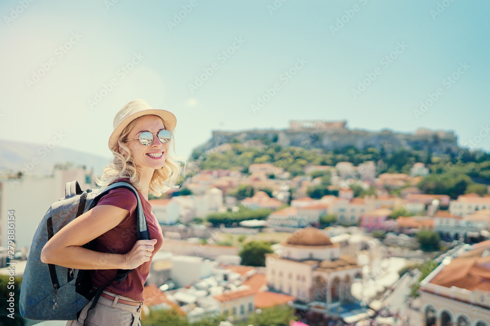 Enjoying vacation in Greece. Young traveling woman with rucksack enjoying view of Athens city and Acropolis.