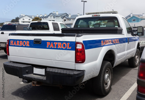 Half Moon Bay, California Harbor Patrol truck parked on quay.