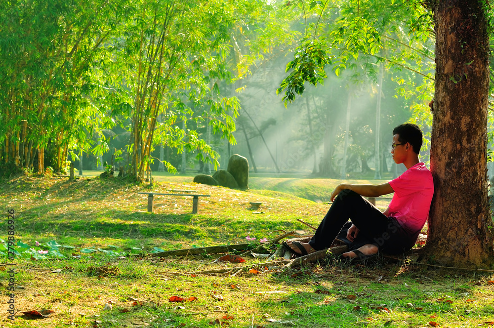 Man sitting alone under tree Man sitting alone under tree