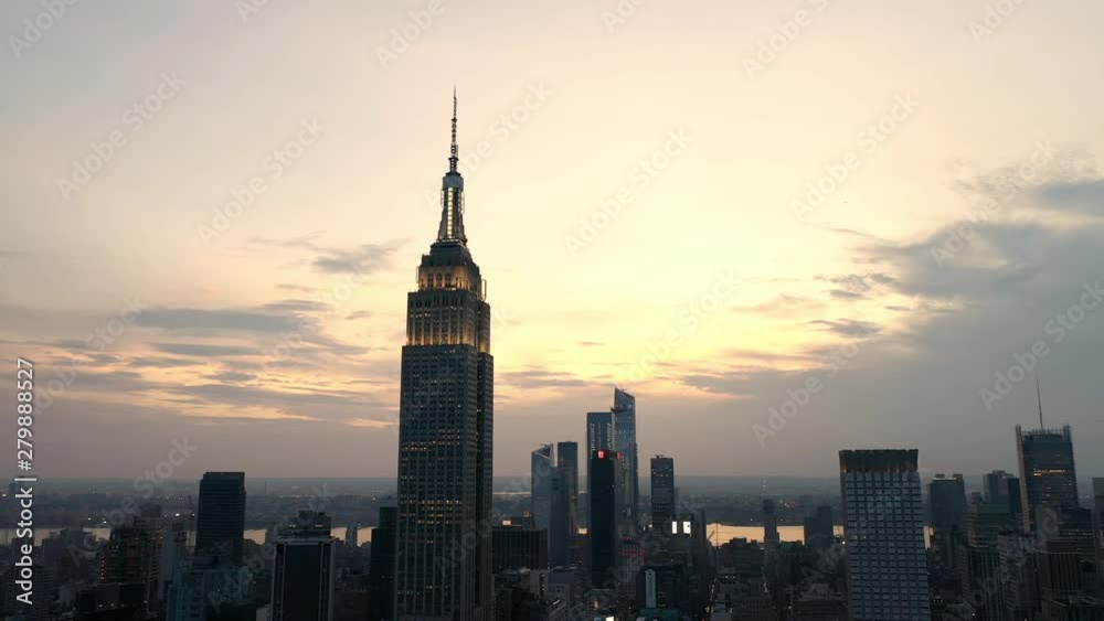 aerial dark city pulling back from Empire State Building at sunset in Manhattan New York NYC