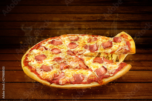 Pizza on wooden table. Flying hot pizza pepperoni closeup with mozzarella cheese and  steam smoke 