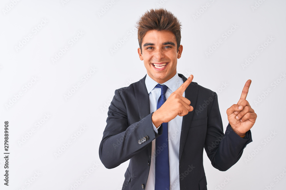 Young handsome businessman wearing suit standing over isolated white background smiling and looking at the camera pointing with two hands and fingers to the side. Young handsome businessman wearing suit standing over isolated white background smiling and looking at the camera pointing with two hands and fingers to the side.