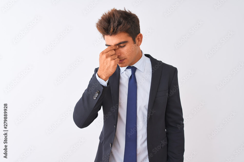 Young handsome businessman wearing suit standing over isolated white background tired rubbing nose and eyes feeling fatigue and headache. Stress and frustration concept. Young handsome businessman wearing suit standing over isolated white background tired rubbing nose and eyes feeling fatigue and headache. Stress and frustration concept.