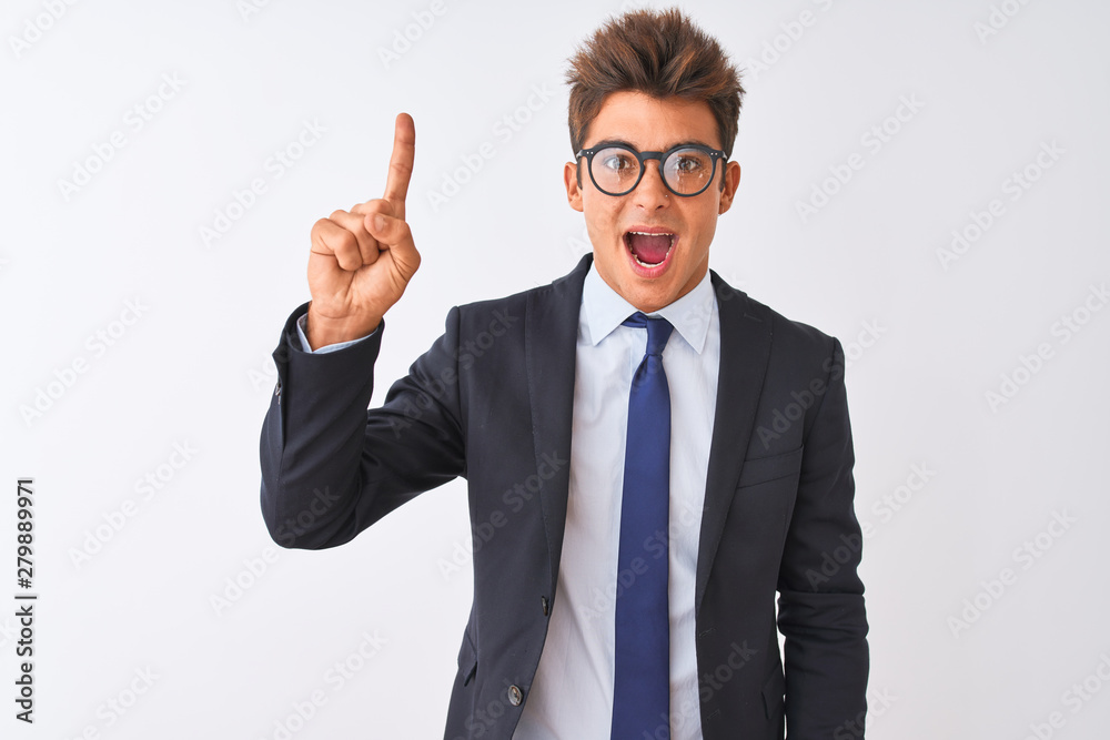Young handsome businessman wearing suit and glasses over isolated white background pointing finger up with successful idea. Exited and happy. Number one. Young handsome businessman wearing suit and glasses over isolated white background pointing finger up with successful idea. Exited and happy. Number one.
