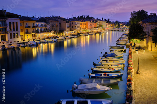 Magnificent sunset view over the Mincio River In the small resort town of Peschiera on Lake Garda, Italy. Photo taken at long exposure.