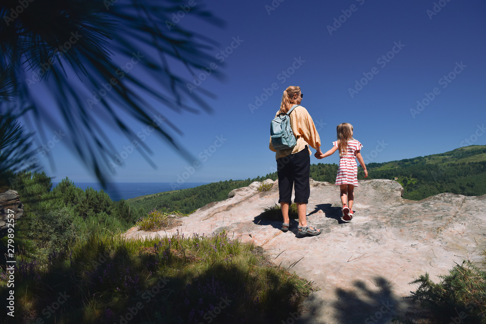 Family relaxing in the valley in Spain. Vacation concept. Mom and child girl walking together