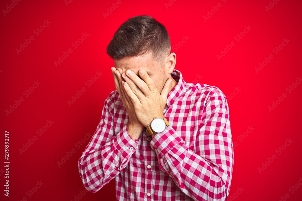 Young handsome man over red isolated background with sad expression covering face with hands while crying. Depression concept. Young handsome man over red isolated background with sad expression covering face with hands while crying. Depression concept.