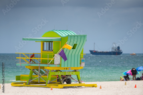 Green Miami Beach lifeguard tower with ocean view in background