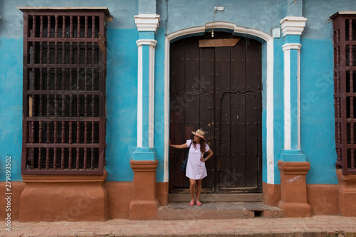 A pretty young woman with hat located at the door of an old colonial house in the colonial town of Trinidad (Cuba) © Gustavo Muñoz