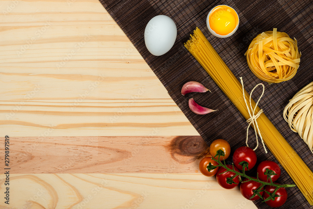 Naklejka premium Composition with different types of pasta on pine wood background. Space for text.