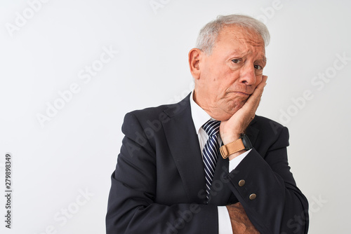 Senior grey-haired businessman wearing suit standing over isolated white background thinking looking tired and bored with depression problems with crossed arms.