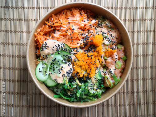 Salmon poke in a bowl with wicker background  photo