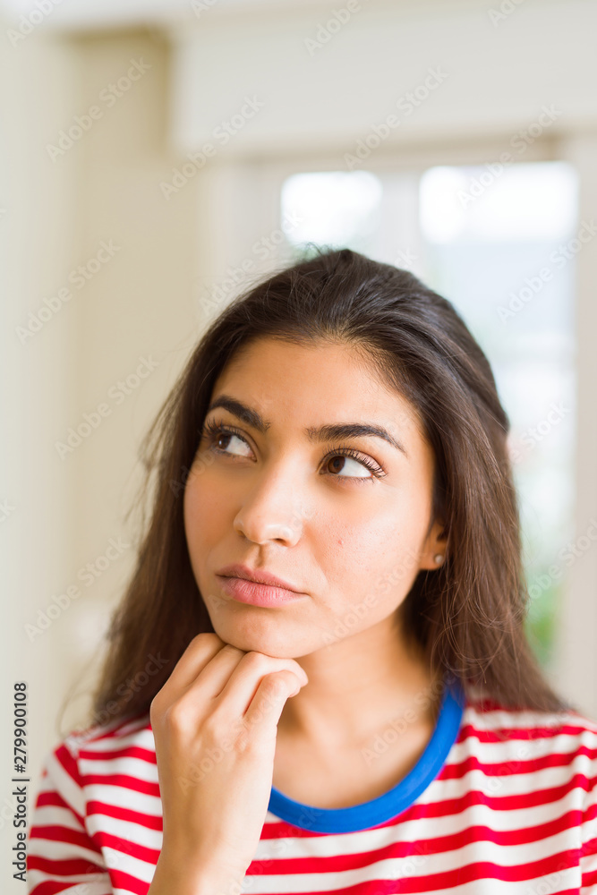 Young beautiful woman thinking and wondering with a hand on chin, doubt concept