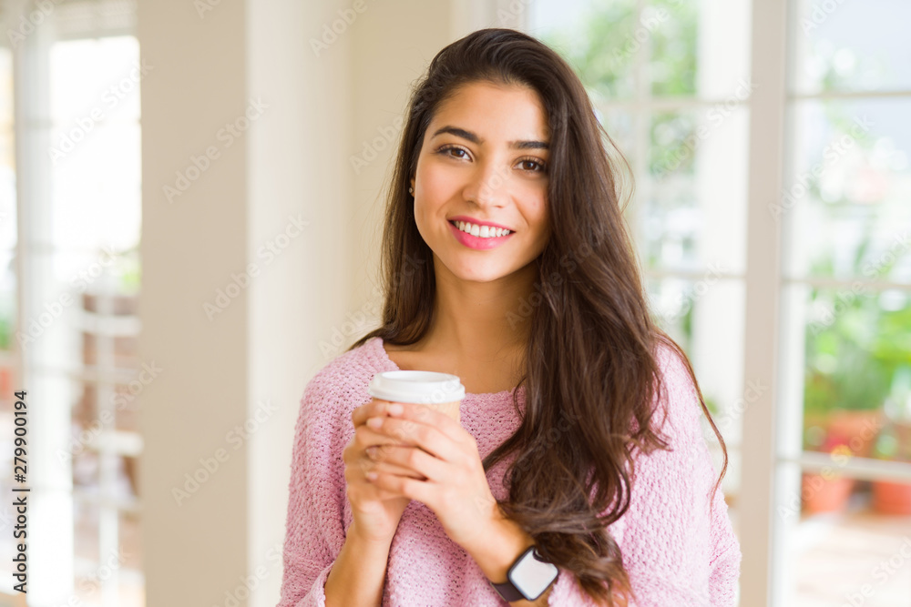 Beautiful young girl drinking a cup of coffee at home and smiling Beautiful young girl drinking a cup of coffee at home and smiling