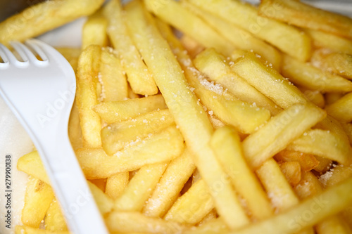 French fries with salt and plastic white fork.