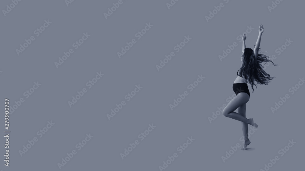 Young beautiful pregnant woman with long healthy curly hair dancing in black underwear on blue isolated background banner. Active pregnancy. Black and white image. Young beautiful pregnant woman with long healthy curly hair dancing in black underwear on blue isolated background banner. Active pregnancy. Black and white image.