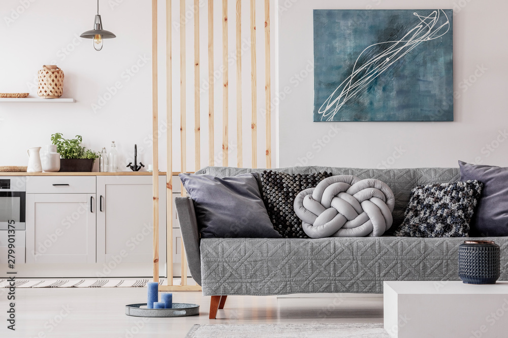 Trendy knot light grey pillow on comfortable scandinavian couch - obrazy, fototapety, plakaty 