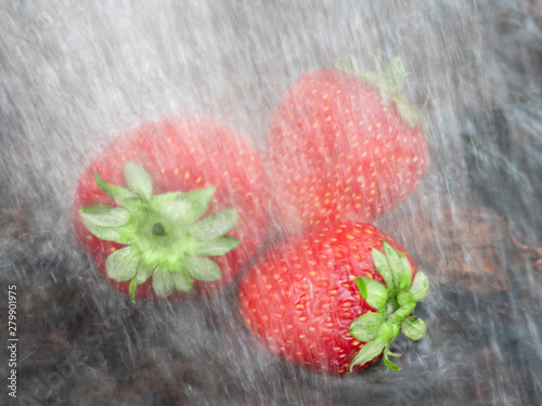 Strawberries in the rain. Three berries of ripe strawberries in water. Close-up. Still life.