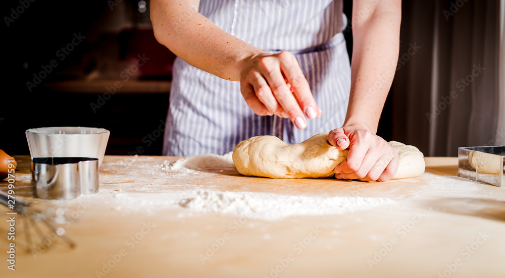 Female hands making dough on wooden table Female hands making dough on wooden table