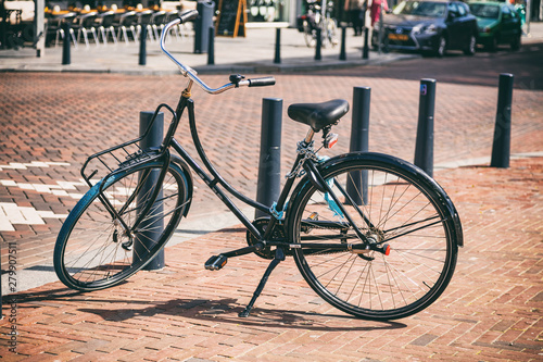 Bicycle black color parked on a sidewalk in Rotterdam city, Netherlands