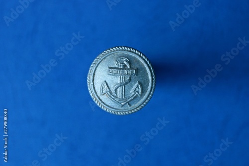 big gray old button with an anchor on a blue background © butus