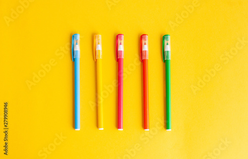 colored pens, accessories for studying on a yellow background