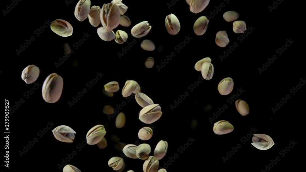Pistachios bouncing against to the camera on a black background in slow motion Pistachios bouncing against to the camera on a black background in slow motion