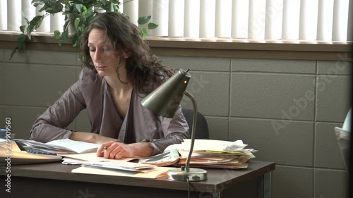 Overwhelmed business woman gives up, slams head on desk, dolly shot