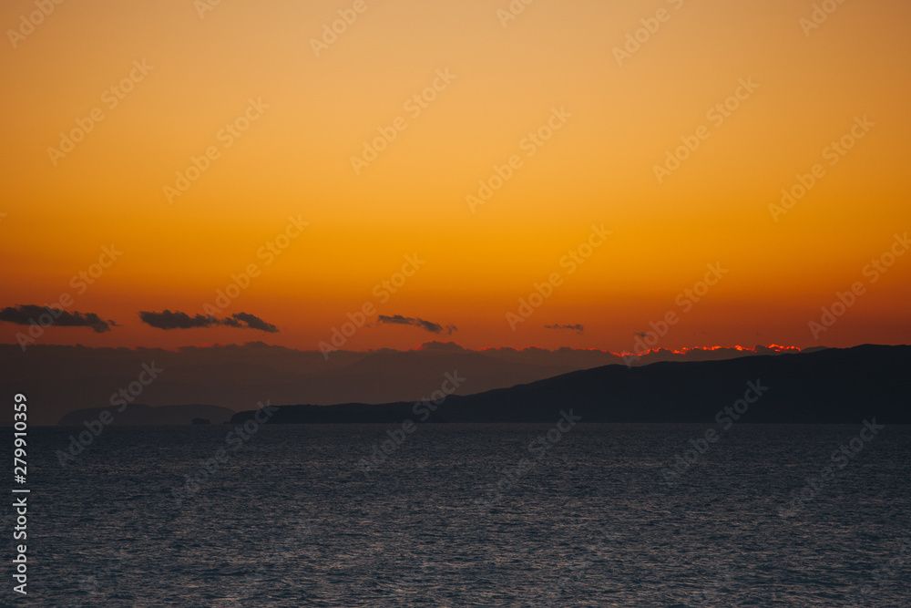 Orange clouds at sunset over the islands of the Saronic Gulf