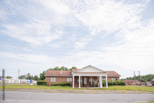 A rundown residential and commercial property in a suburban area with a for lease sign.