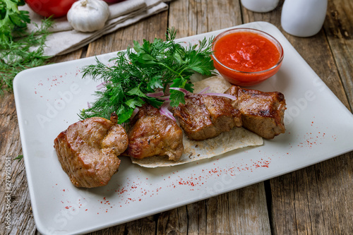Kebab of veal on wooden table