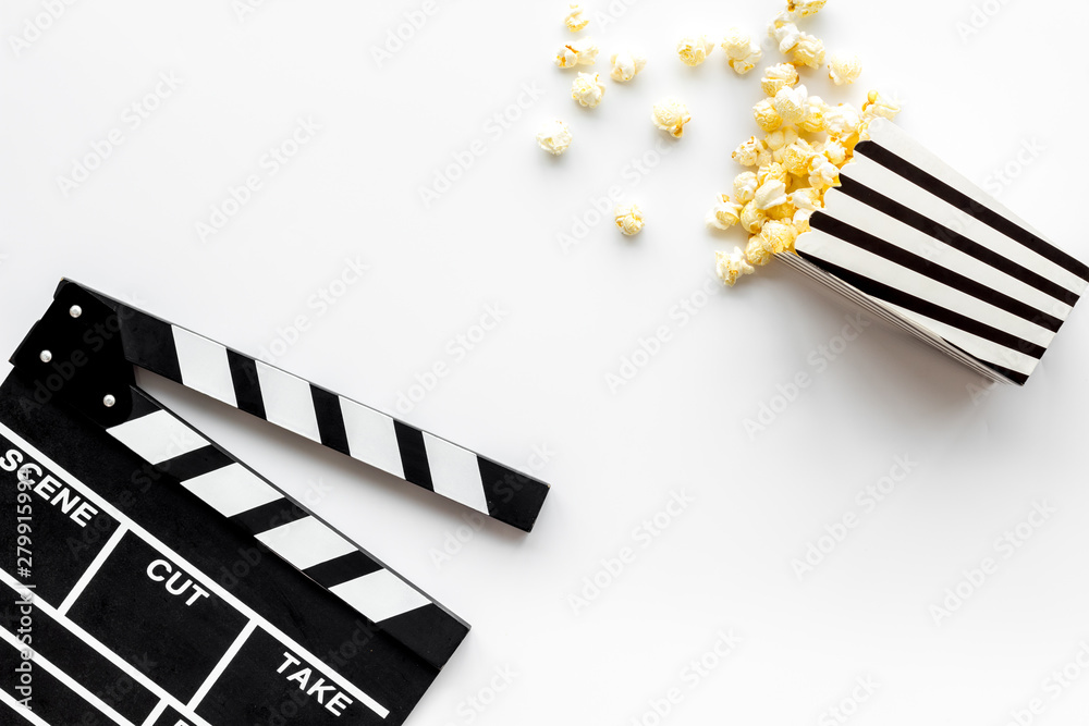 Watch film in cinema with popcorn and clapperboard on white background top view