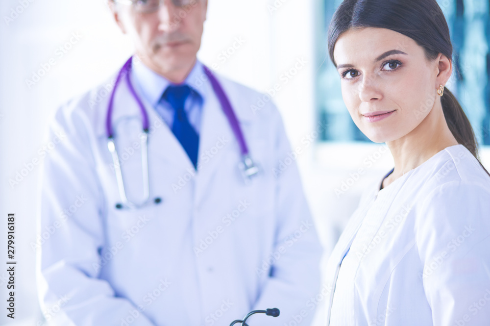 Two doctors in conference room in hospital, one of them looking at the camera Two doctors in conference room in hospital, one of them looking at the camera