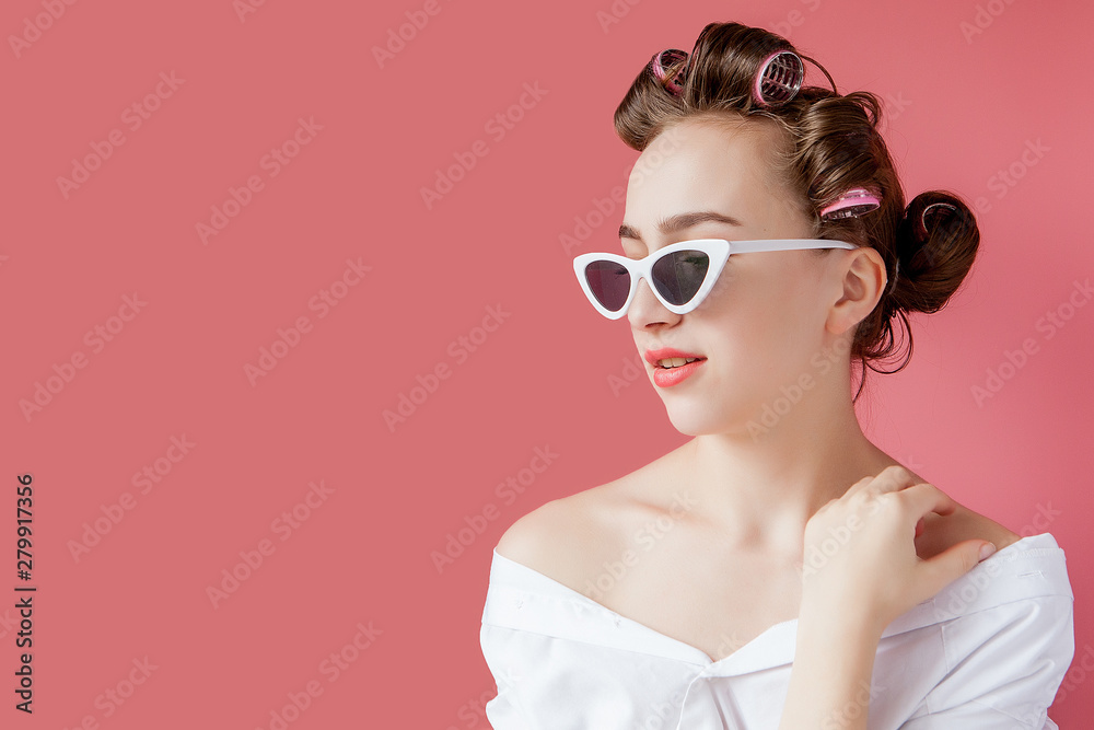 Beautiful girl in hair curlers on pink background Beautiful girl in hair curlers on pink background