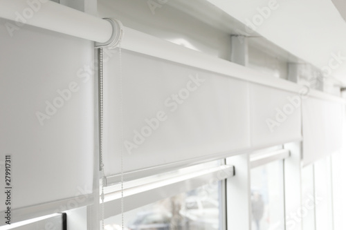 Modern window with white roller blinds indoors
