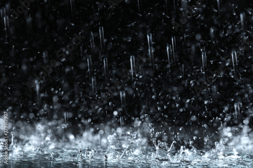 Heavy rain falling down on ground against dark background Fototapet