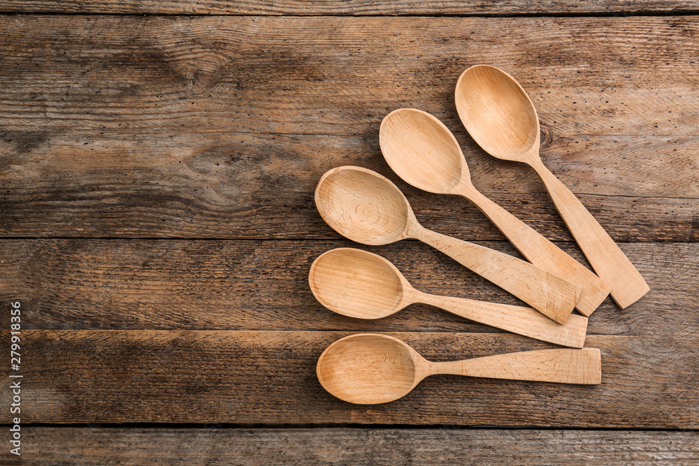 Clean empty spoons on wooden background, top view. Space for text Clean empty spoons on wooden background, top view. Space for text