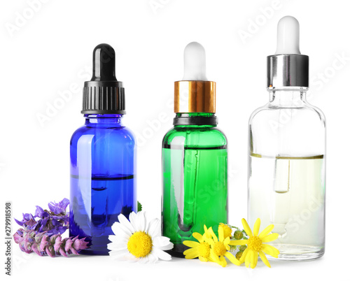 Bottles of herbal essential oils and wildflowers isolated on white