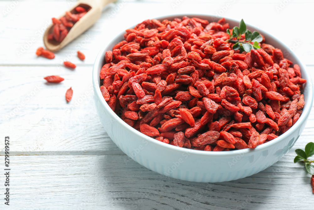 Bowl of dried goji berries on white wooden table, closeup. Healthy superfood Bowl of dried goji berries on white wooden table, closeup. Healthy superfood