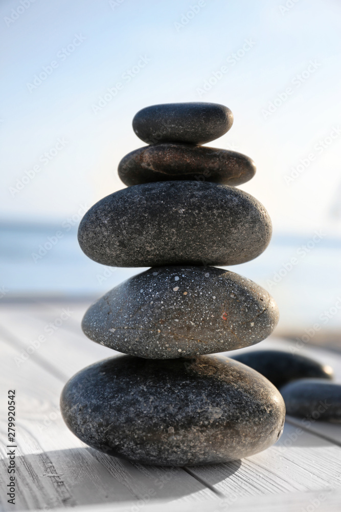 Stack of stones on wooden deck outdoors. Zen concept Stack of stones on wooden deck outdoors. Zen concept