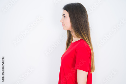 Young beautiful woman wearing casual red t-shirt over white isolated background looking to side, relax profile pose with natural face with confident smile.