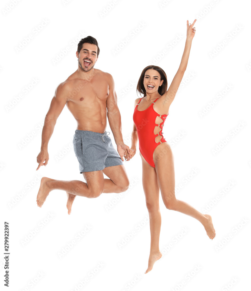 Young attractive couple in beachwear jumping on white background Young attractive couple in beachwear jumping on white background