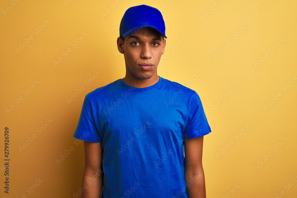 Young handsome arab delivery man standing over isolated yellow background depressed and worry for distress, crying angry and afraid. Sad expression.